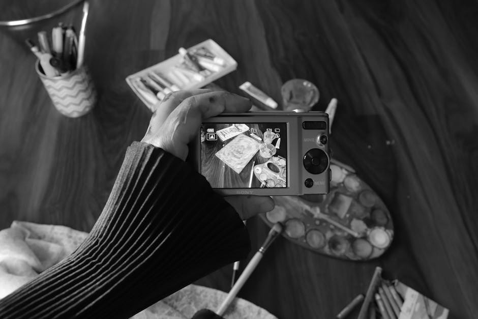 Black and white photo of an artistic workspace captured on a camera screen, showcasing creativity.