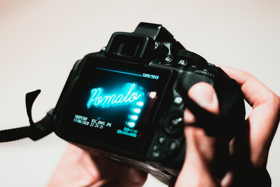 A DSLR camera screen displaying an image with hands holding the device, highlighting photography process.
